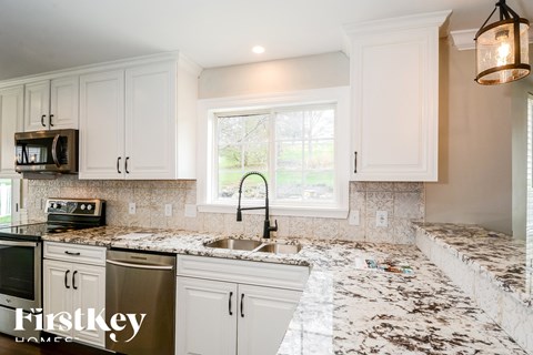 a kitchen with marble counter tops and white cabinets
