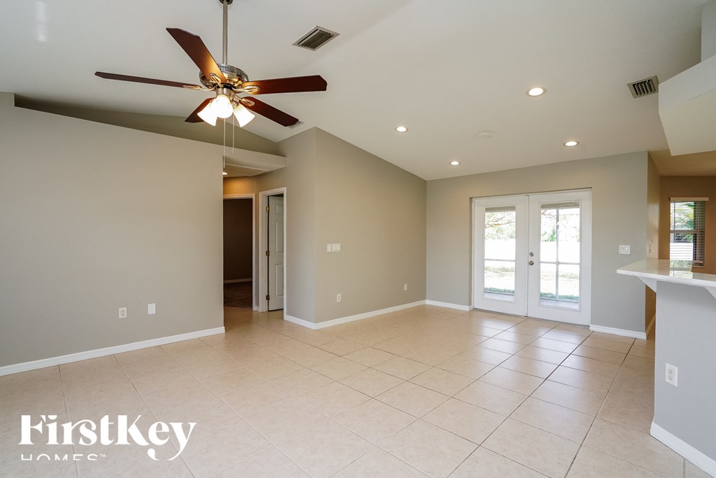 an empty living room with a ceiling fan