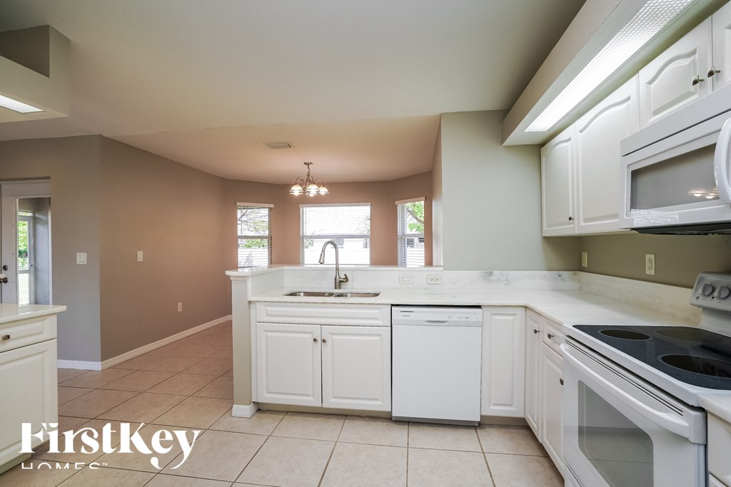 a kitchen with white cabinets and a sink and a stove