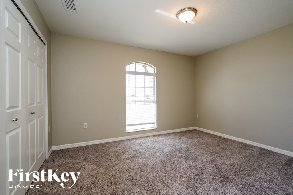 a bedroom with carpet and a window and a door