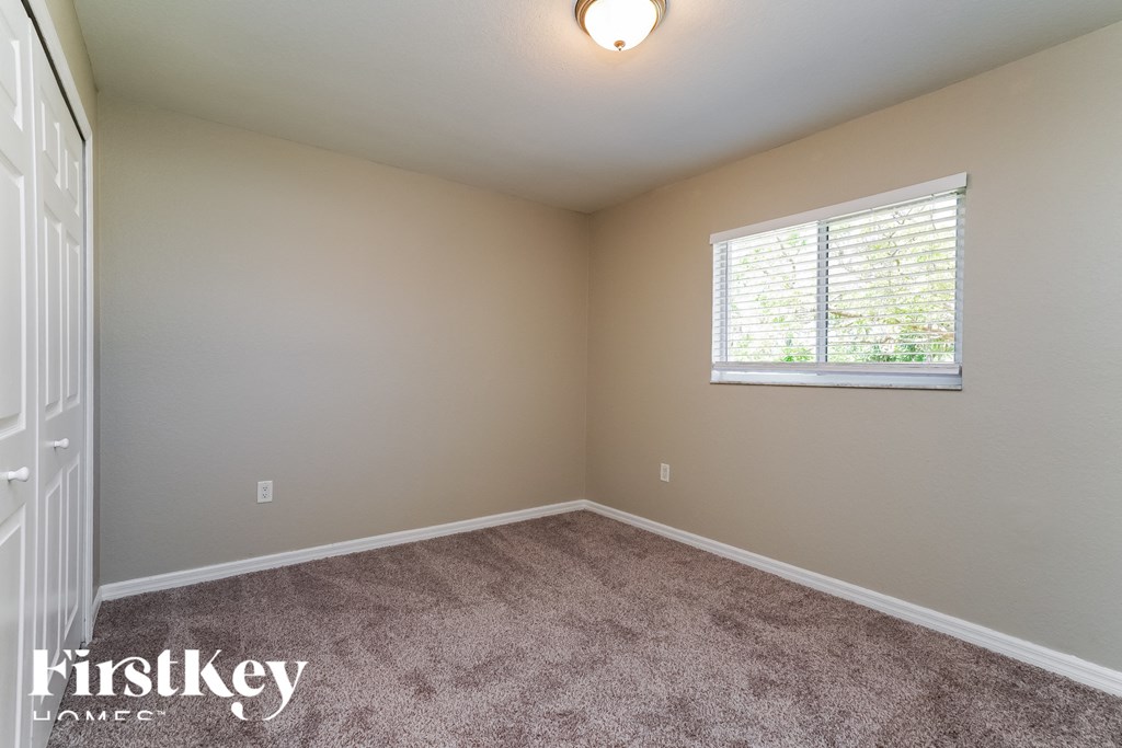 a bedroom with a carpeted floor and a window