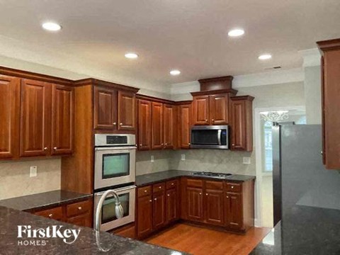 A kitchen with wooden cabinets and a black countertop.