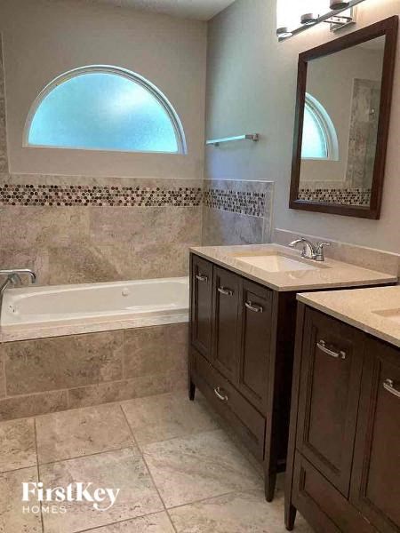 a bathroom with two sinks and a bath tub