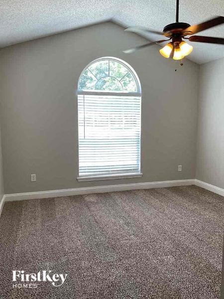 an empty room with a ceiling fan and a window