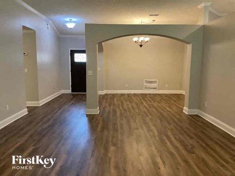 an empty living room with a hard wood floor