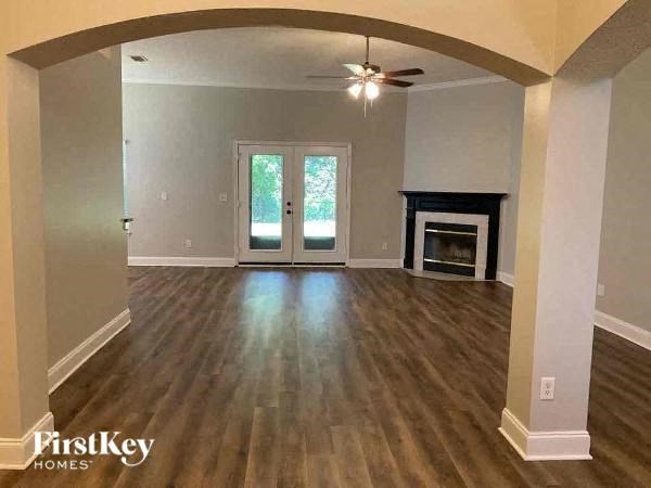a empty living room with a fireplace and a ceiling fan