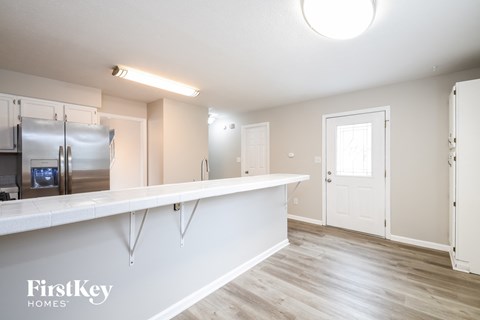 A kitchen area with a refrigerator and a counter.