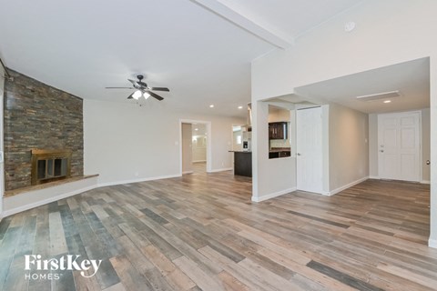 a living room with a ceiling fan and a fireplace