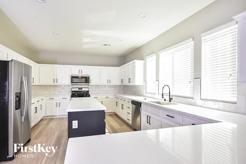 A modern kitchen with white cabinets and appliances.