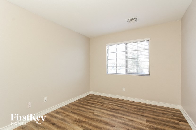 a bedroom with a window and a wooden floor