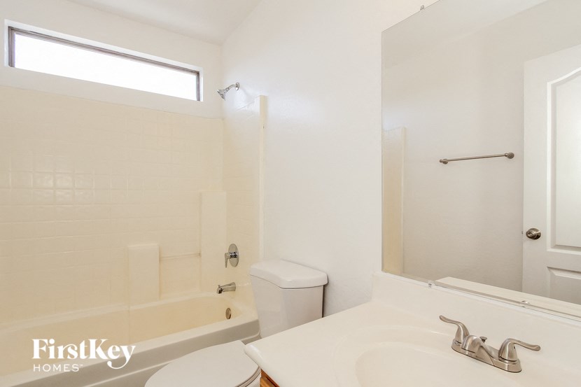 a white bathroom with a tub and a sink and a toilet