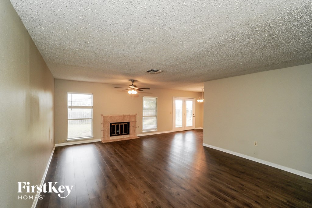 an empty living room with wood floors and a fireplace