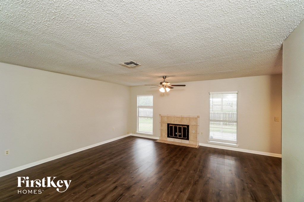 an empty living room with wood floors and a fireplace
