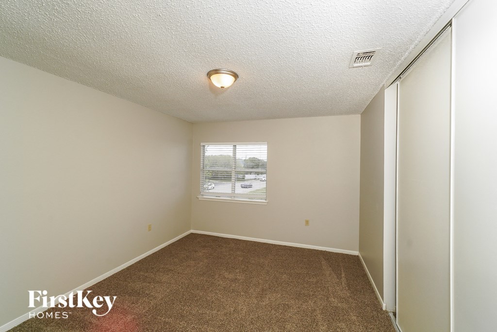 a bedroom with a carpeted floor and a window