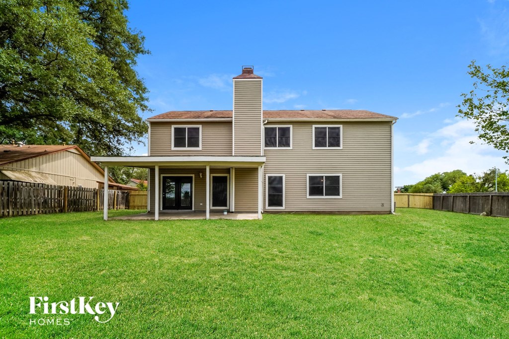 the back of a house with a yard and a fence