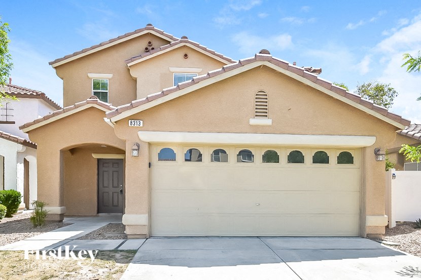 A two-story house with a garage and a brown door.