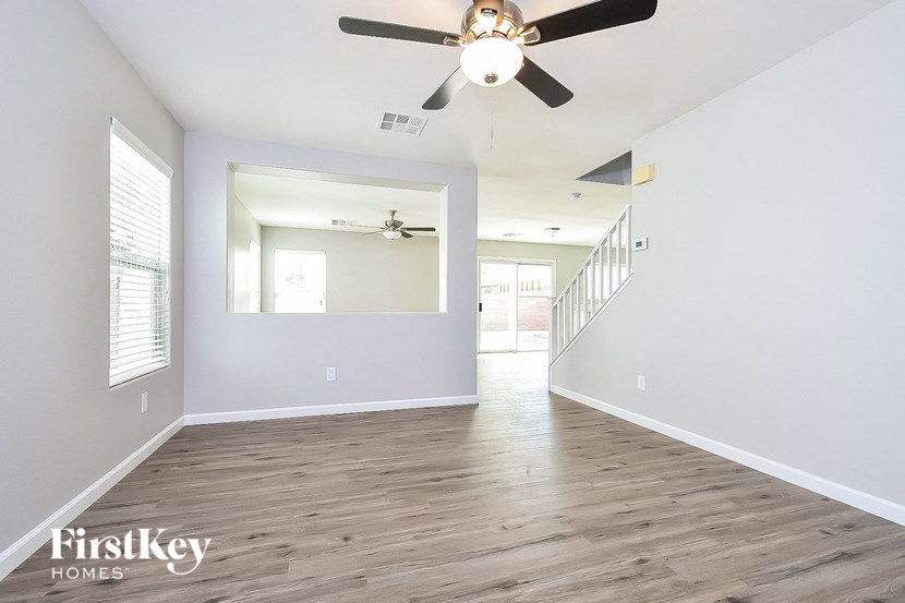 A spacious room with a ceiling fan and wooden flooring.