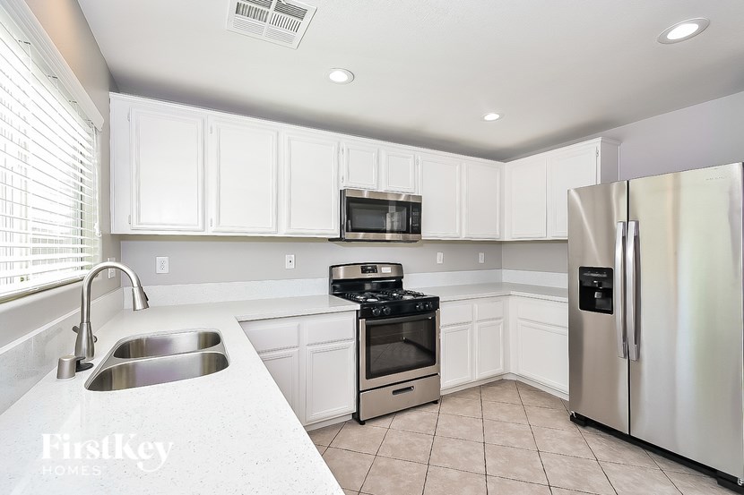 A kitchen with white cabinets and stainless steel appliances.