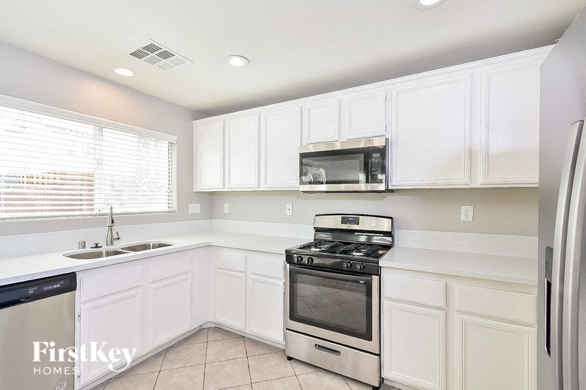 A kitchen with white cabinets and appliances.