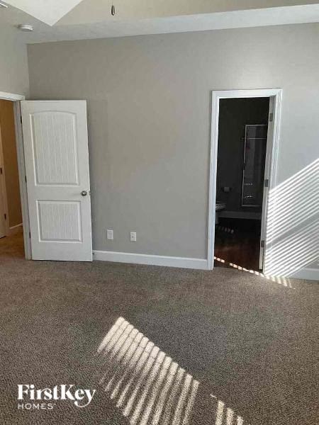 an empty room with a door and a carpeted floor