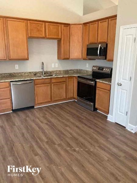 a kitchen with wood flooring and wooden cabinets