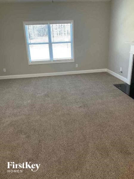 a carpeted living room with a window