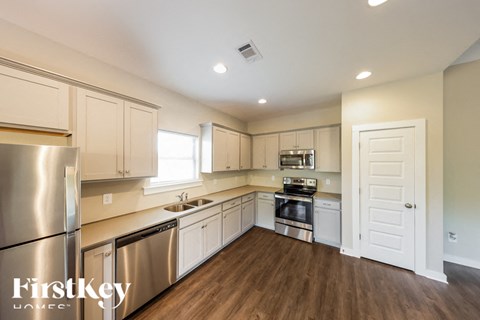 A kitchen with wooden floors and stainless steel appliances.