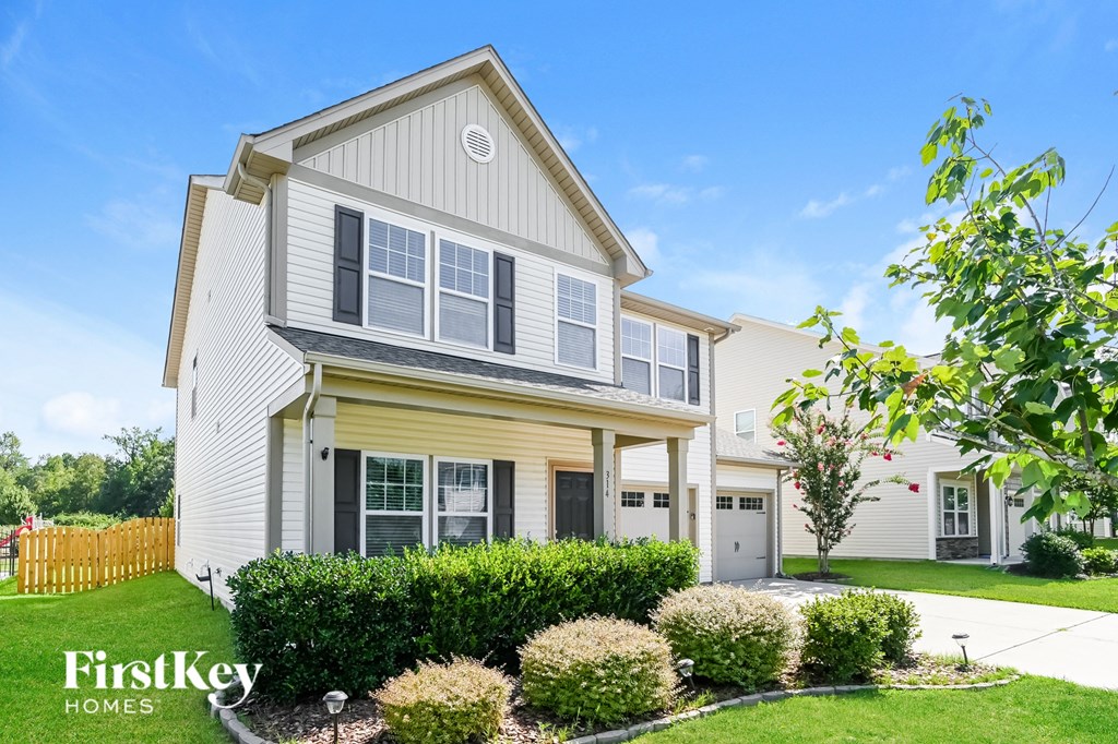 a yellow and with a yard and a white fence