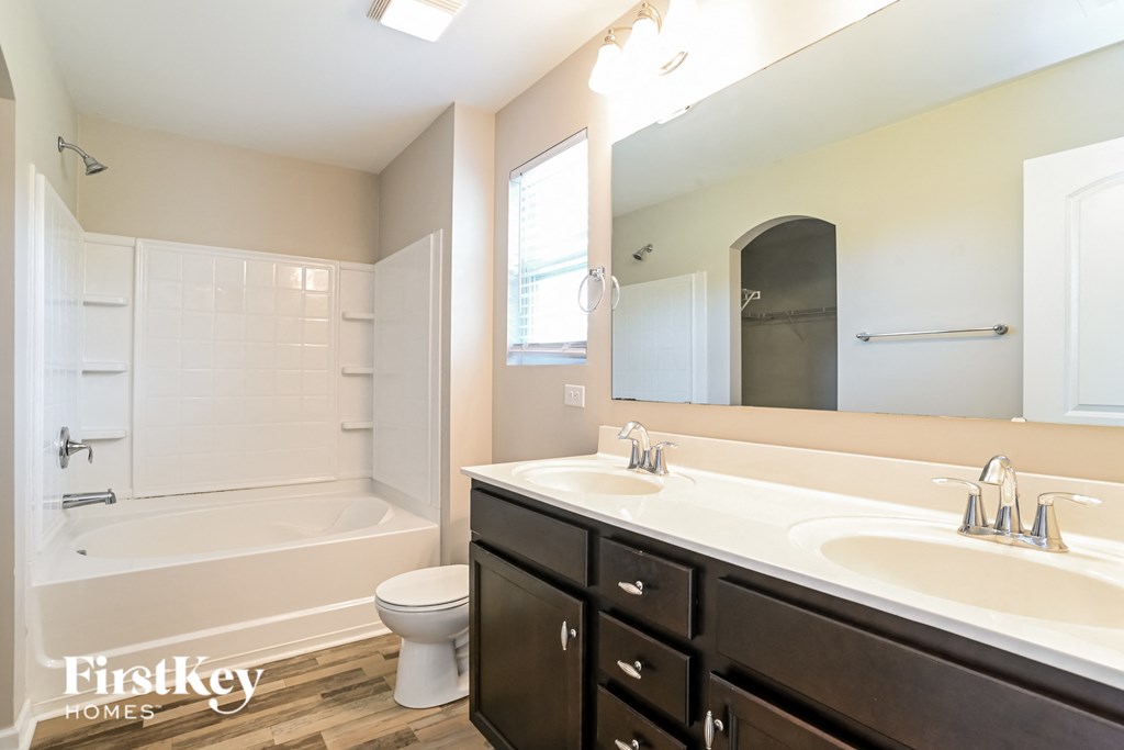 a bathroom with two sinks and a tub and a toilet