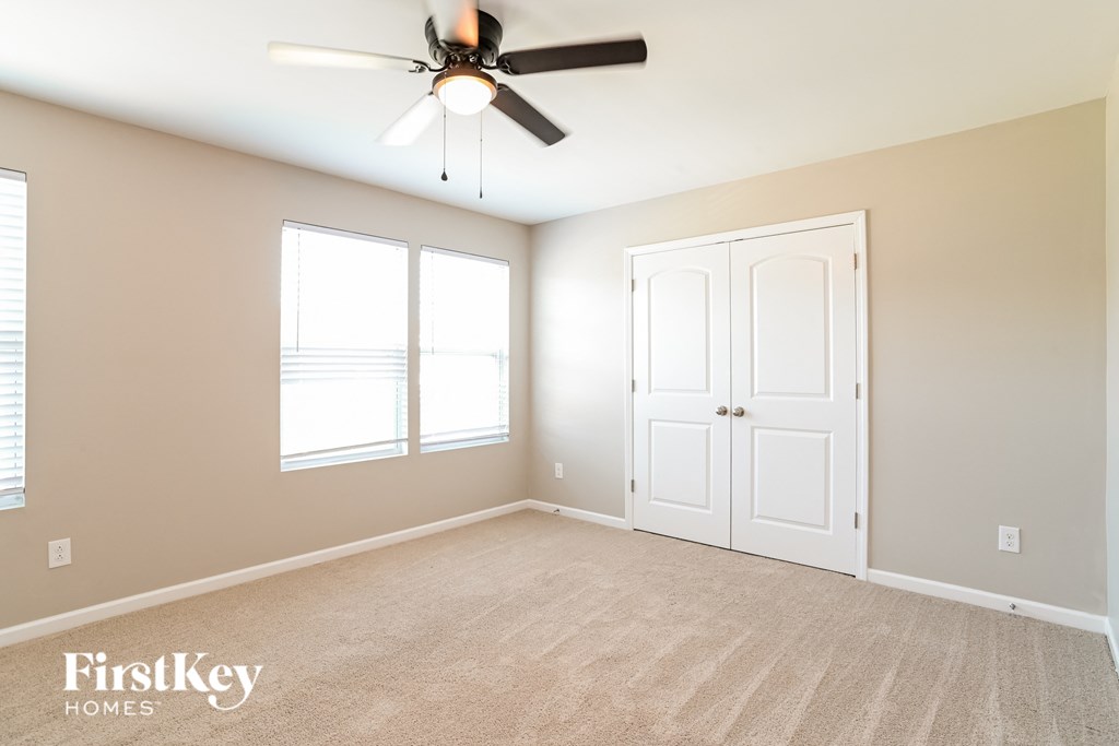a bedroom with a ceiling fan and a closet