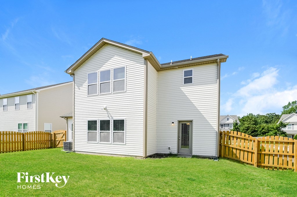 a white house with a backyard and a wooden fence