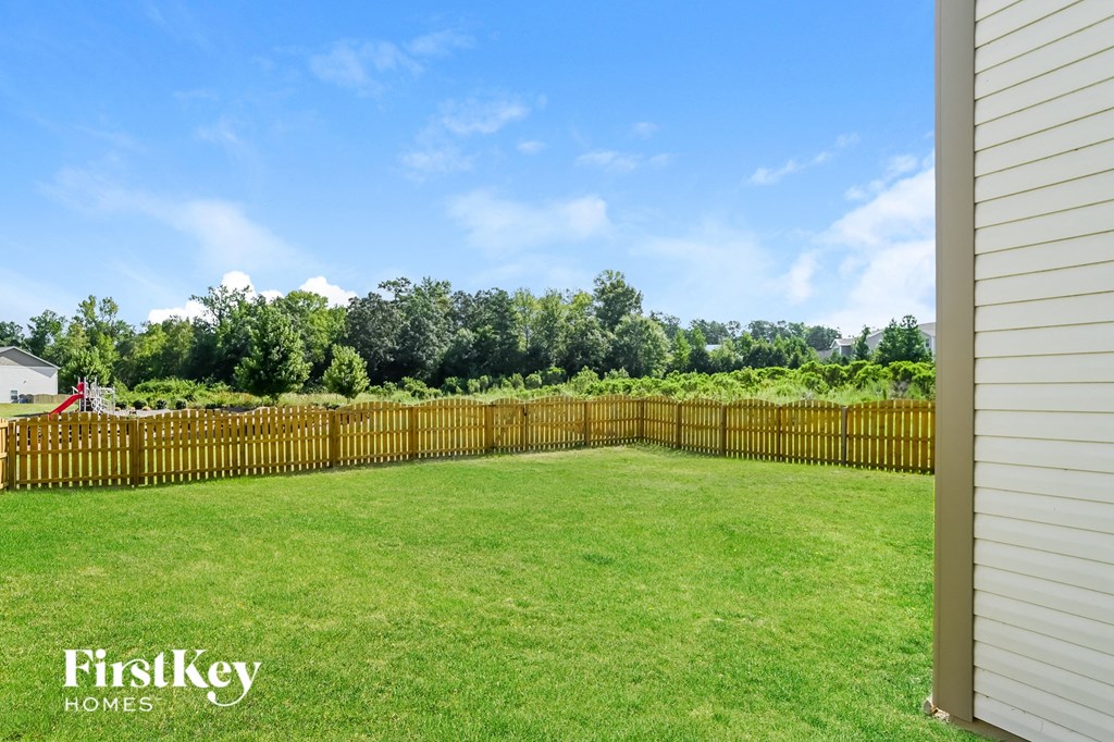 a backyard with a wooden fence and a green lawn