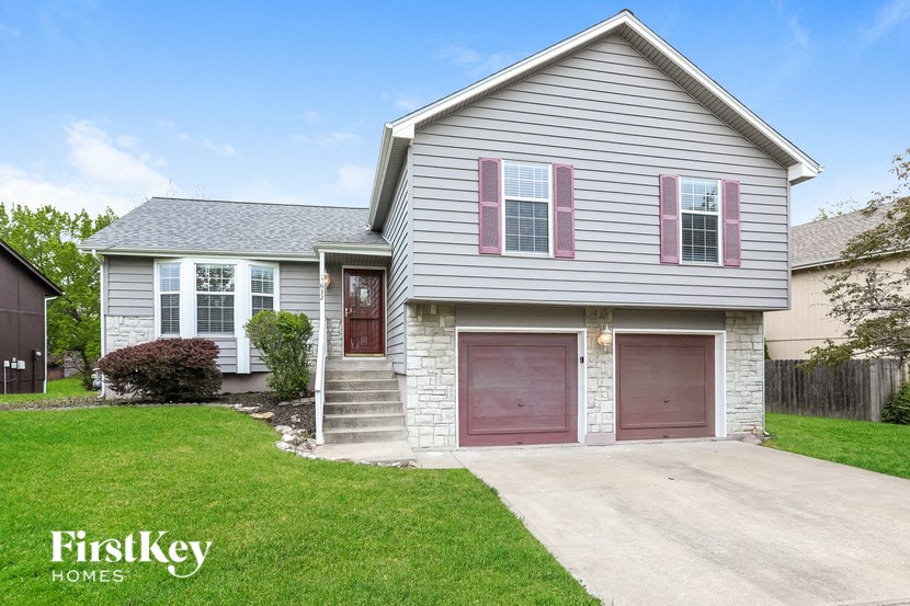 a white house with a driveway and a red garage door
