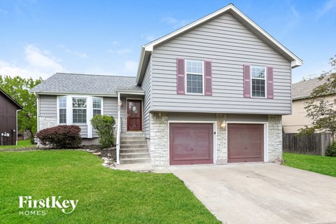 a white house with a driveway and a red garage door