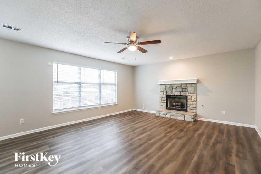 a living room with a fireplace and a ceiling fan