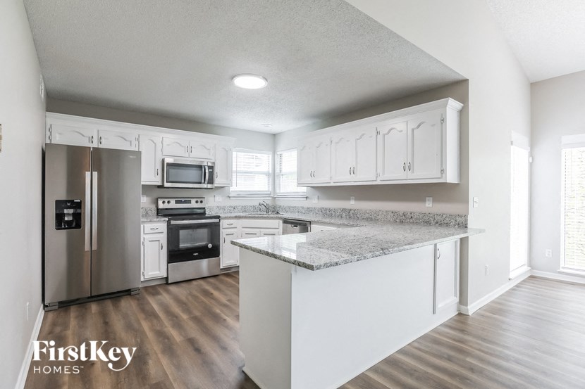 a kitchen with white cabinets and stainless steel appliances