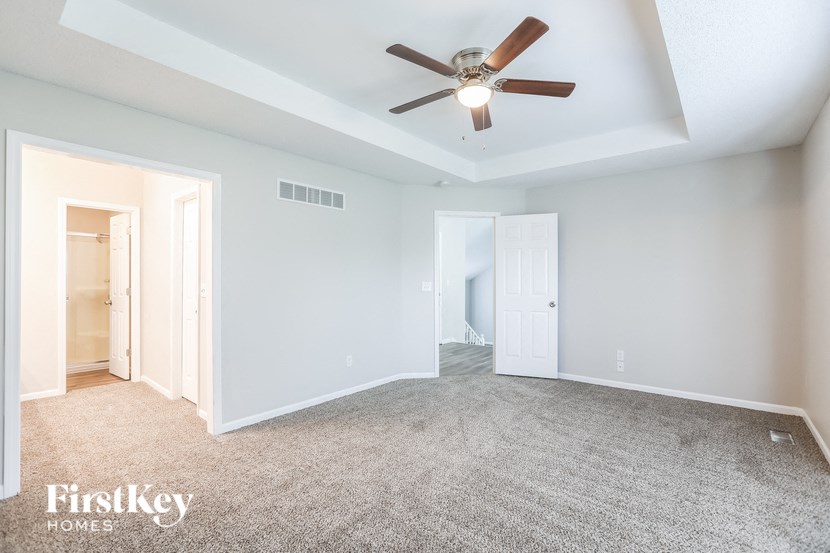 an empty living room with a ceiling fan