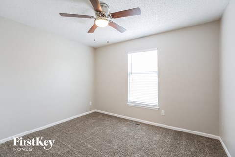 a bedroom with a ceiling fan and a window
