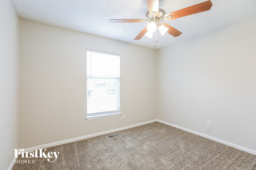 a bedroom with a ceiling fan and a window