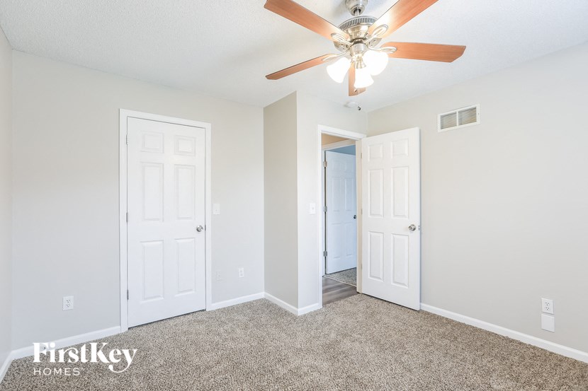 a bedroom with two doors and a ceiling fan