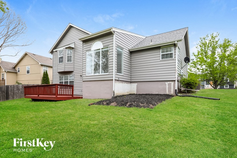 a house with a yard and a red deck