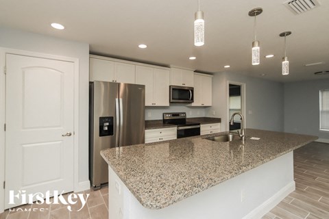 a kitchen with white cabinets and a granite counter top