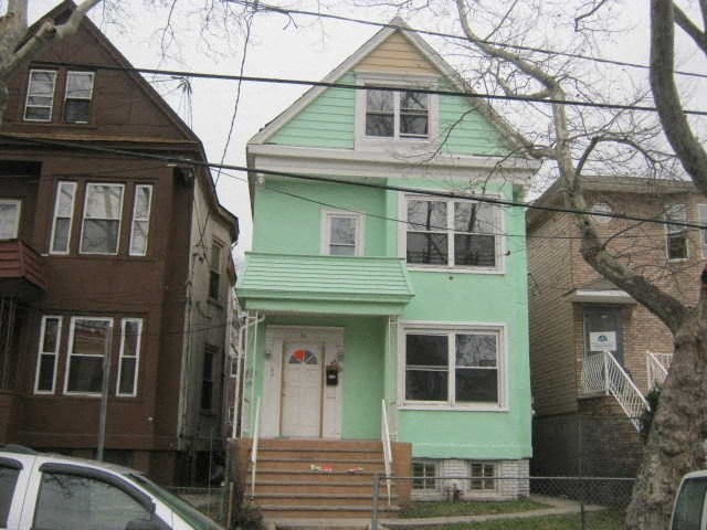 a green house on the corner of a street