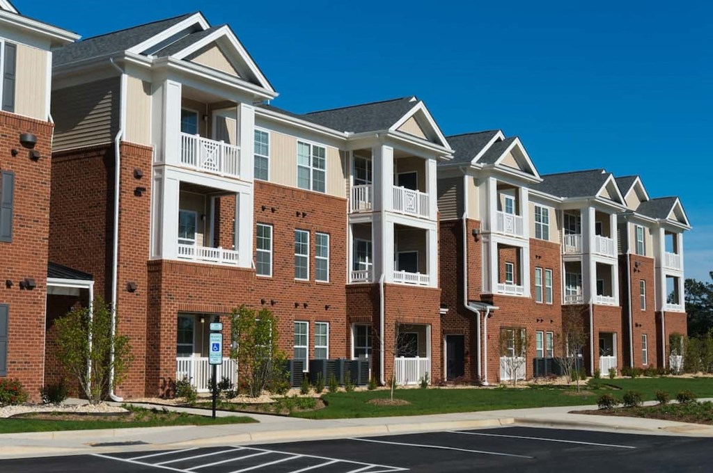 a row of brick and white apartment buildings on a street