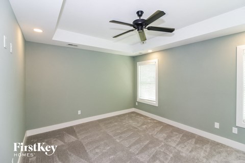 the living room has a ceiling fan and a carpet
