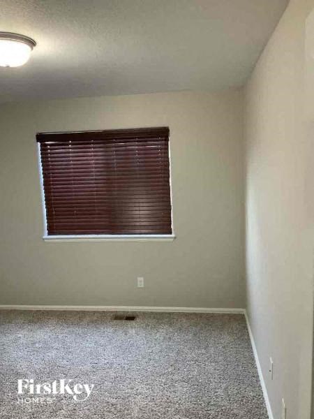 a empty room with a window and a carpeted floor