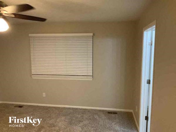 an empty room with a window and a ceiling fan