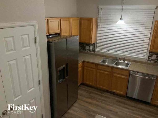 a kitchen with a stainless steel refrigerator and a sink