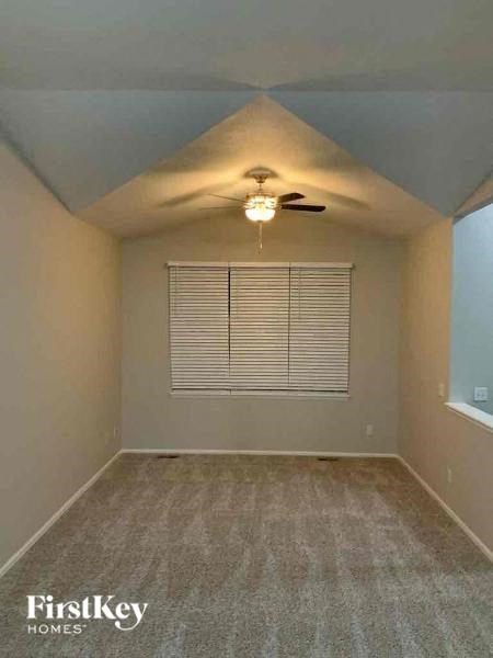 an empty room with a ceiling fan and a window
