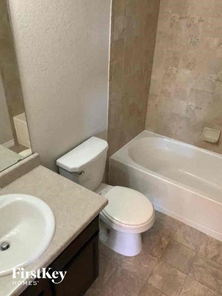 a bathroom with a toilet and a sink and a bath tub